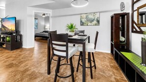 Un área de comedor moderna con una mesa, sillas y una lámpara colgante.