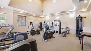 Un gimnasio amplio con cintas de correr, elípticas y equipo de pesas.