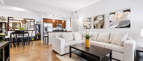A modern living room with a sofa, coffee table, and artwork on the wall.