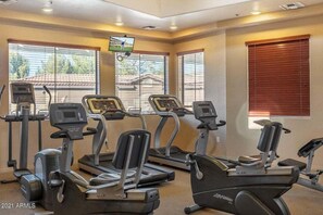 A gym with four treadmills, a TV mounted on the wall, and large windows with blinds. - Southern #1083 Mesa (Mesa)