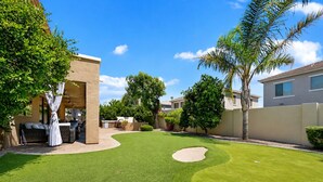 A backyard with artificial grass, a patio area, and a pool. - The Jade House Queen Creek (Queen Creek)