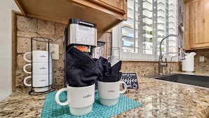 A kitchen with a coffee machine, two coffee cups, a napkin holder, and a sign that says 'Rise & Shine It's Coffee Time.' - The Jade House Queen Creek (Queen Creek)
