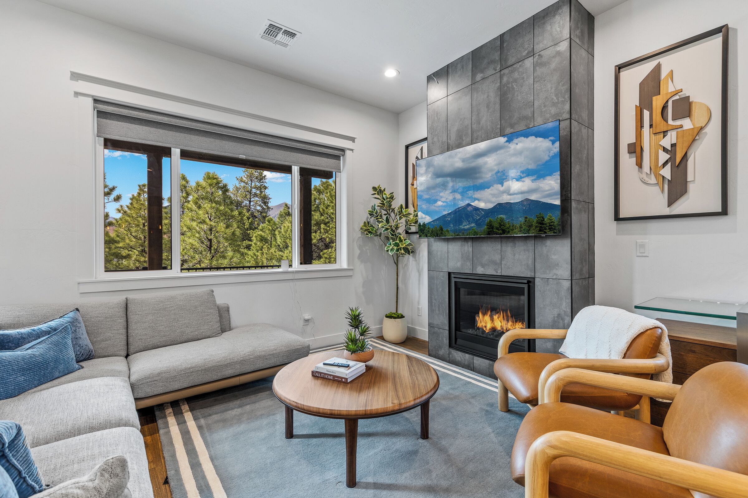A modern living room with a sofa, a round coffee table, and a fireplace.