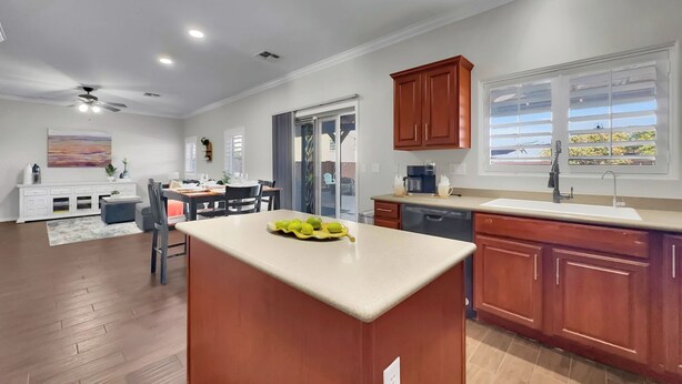 Una cocina moderna con armarios de madera, una isla central y un comedor con mesa y sillas.