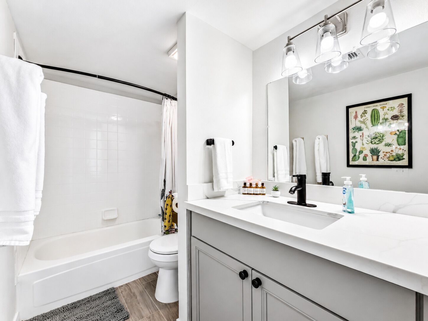 Un baño moderno con ducha, inodoro y tocador con espejo.