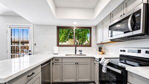 Una cucina moderna con forno a incasso, microonde ed elettrodomestici in acciaio inossidabile.