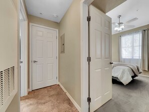 Un dormitorio con cama, ventilador de techo y ventana con cortinas.