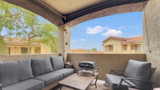 A covered outdoor seating area with a sofa, chairs, and a table. - Southern #2059 Mesa (Mesa)