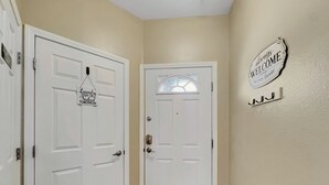 A hallway with two white doors, one with a laundry sign and another with a welcome sign. - Southern #2059 Mesa (Mesa)