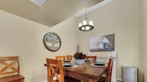 A dining area with a wooden table, chairs, a chandelier, a family tree artwork, and a painting on the wall. - Southern #2059 Mesa (Mesa)