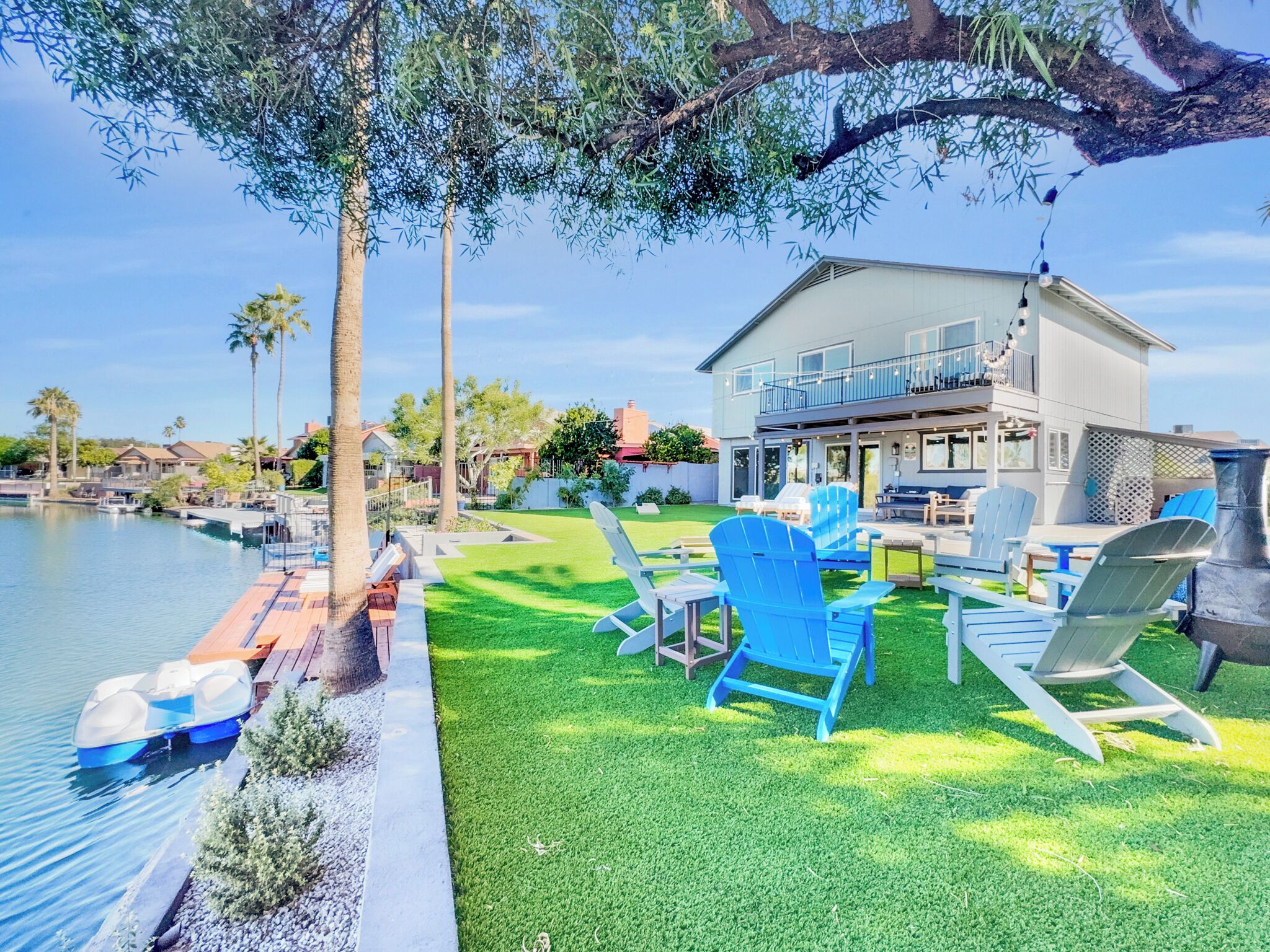 Una casa con piscina, mobiliario de exterior y vista al agua.
