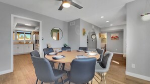 A modern dining area with a round table, chairs, and a ceiling fan. - Yucca Mesa (Mesa)