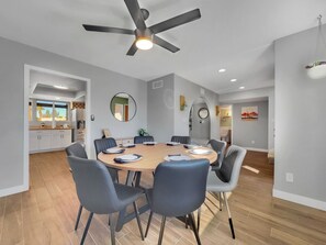 A modern dining area with a round table, chairs, and a ceiling fan. - Yucca Mesa (Mesa)