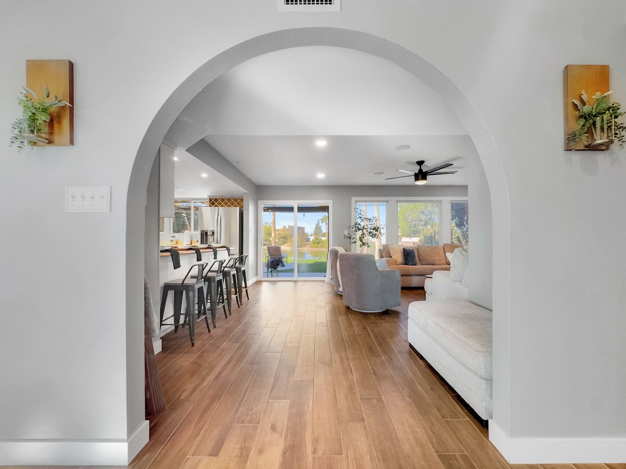 A modern interior with a kitchen, dining area, and living room connected by an archway.