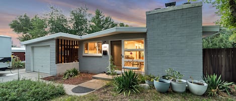 A modern house with a garage, a covered porch, and a well-maintained garden.