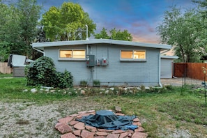 Eingeschossiges Haus mit Garage, überdachter Außenlounge und gepflegtem Rasen.