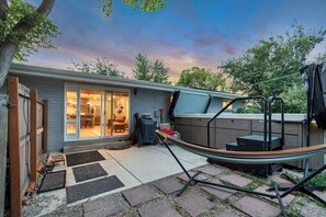 A backyard with a covered patio, a hammock, and a wooden deck. - Relaxing Mid-Century Home Near Ski Resorts with SwimSpa & EV Charger (Cottonwood Heights)