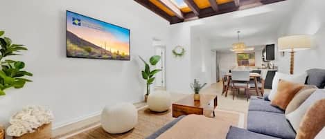 A modern living room with a sofa, a coffee table, and a TV mounted on the wall.
