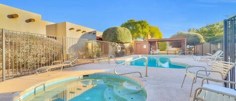 A swimming pool area with multiple pools and lounge chairs.