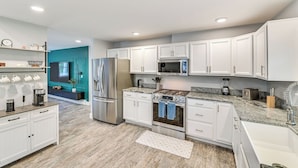 A modern kitchen with white cabinets, stainless steel appliances, and a granite countertop. - Fish and Swim: Home w/ Catskill Creek Views! (East Durham)