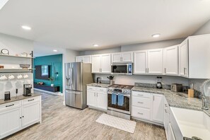 A modern kitchen with white cabinets, stainless steel appliances, and a granite countertop. - Fish and Swim: Home w/ Catskill Creek Views! (East Durham)