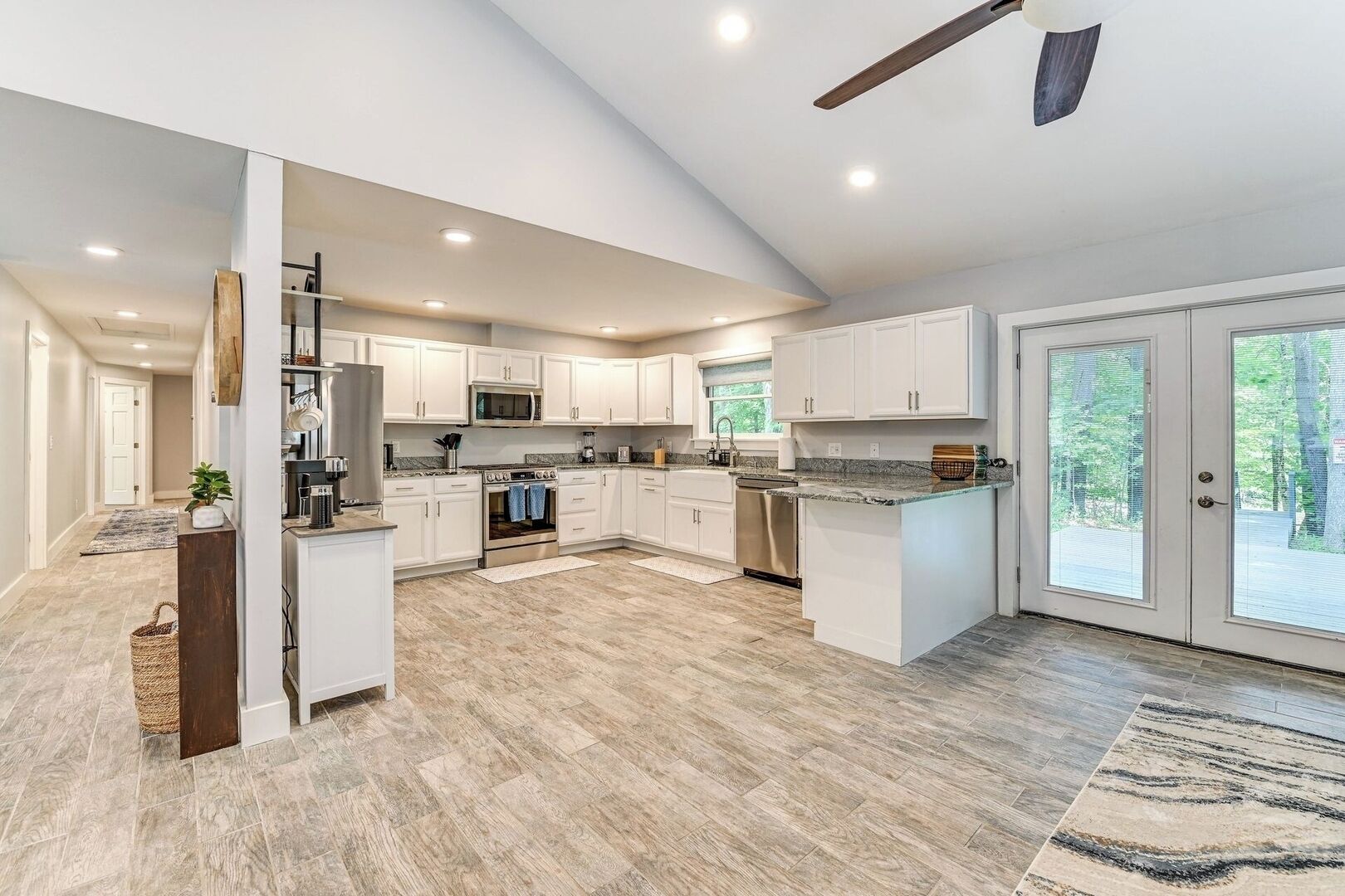 A spacious kitchen with white cabinetry, a central island, and a large window providing natural light.