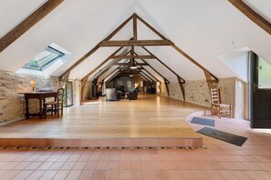 A spacious attic room with a sloped ceiling, wooden beams, and a skylight. - Holiday Home 'Folperdrix' with Private Terrace and Garden (Surzur)