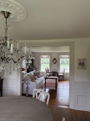 Una habitación con candelabro, una mesa de comedor, un sofá y una silla.