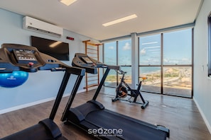 Ein modernes Fitnessstudio mit Laufbändern, einem Ergometer und einem Rudergerät.