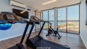 A modern gym with treadmills, a stationary bike, and a rowing machine. - Studio in Cond. With Pool and gym Soa0906 (Salvador)