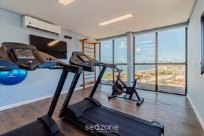 Ein modernes Fitnessstudio mit Laufbändern, einem Ergometer und einem Rudergerät.