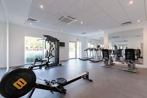 Ein Fitnessstudio mit Laufbändern, Krafttrainingsgeräten und Spiegeln.