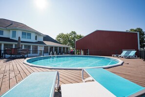 A swimming pool with a deck, lounge chairs, and a covered area. - Beautiful 4-Bedroom Modern Farmhouse located outside of Saint Joseph, IL (Saint Joseph)