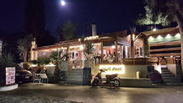 A restaurant with outdoor seating, a motorcycle parked in front, and a sign indicating the menu. - Apartment 'Theodora' with Private Terrace, Wi-Fi and Air Conditioning (Panormos)