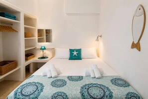 Ein Hotelzimmer mit einem Bett, einem Nachttisch, einer Lampe, einem Schrank und einer Wanddekoration.