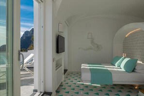 A bedroom with a bed, a TV, and a view of mountains.