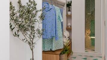 A hallway with a glass vase, a plant, a wooden cabinet, and a door leading to another room.