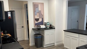 A modern kitchen with white cabinetry, a black countertop, and a stainless steel refrigerator. - 	
Quiet Executive Retreat | Balcony, Parking, Near Hospital & UdeM” (Moncton)