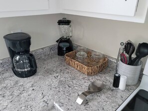 Eine Küche mit Kaffeemaschine, Mixer und Gewürzregal.