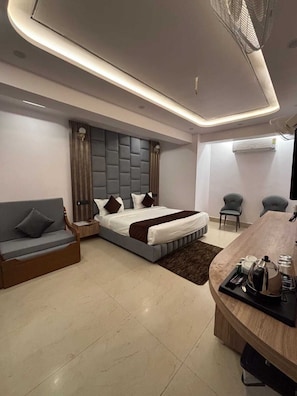 Un dormitorio moderno con cama, sofá, escritorio y aire acondicionado.