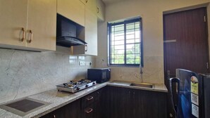 Habitación doble Deluxe, balcón, vista al mar | Cocina privada | Refrigerador, microondas y utensilios de cocina 