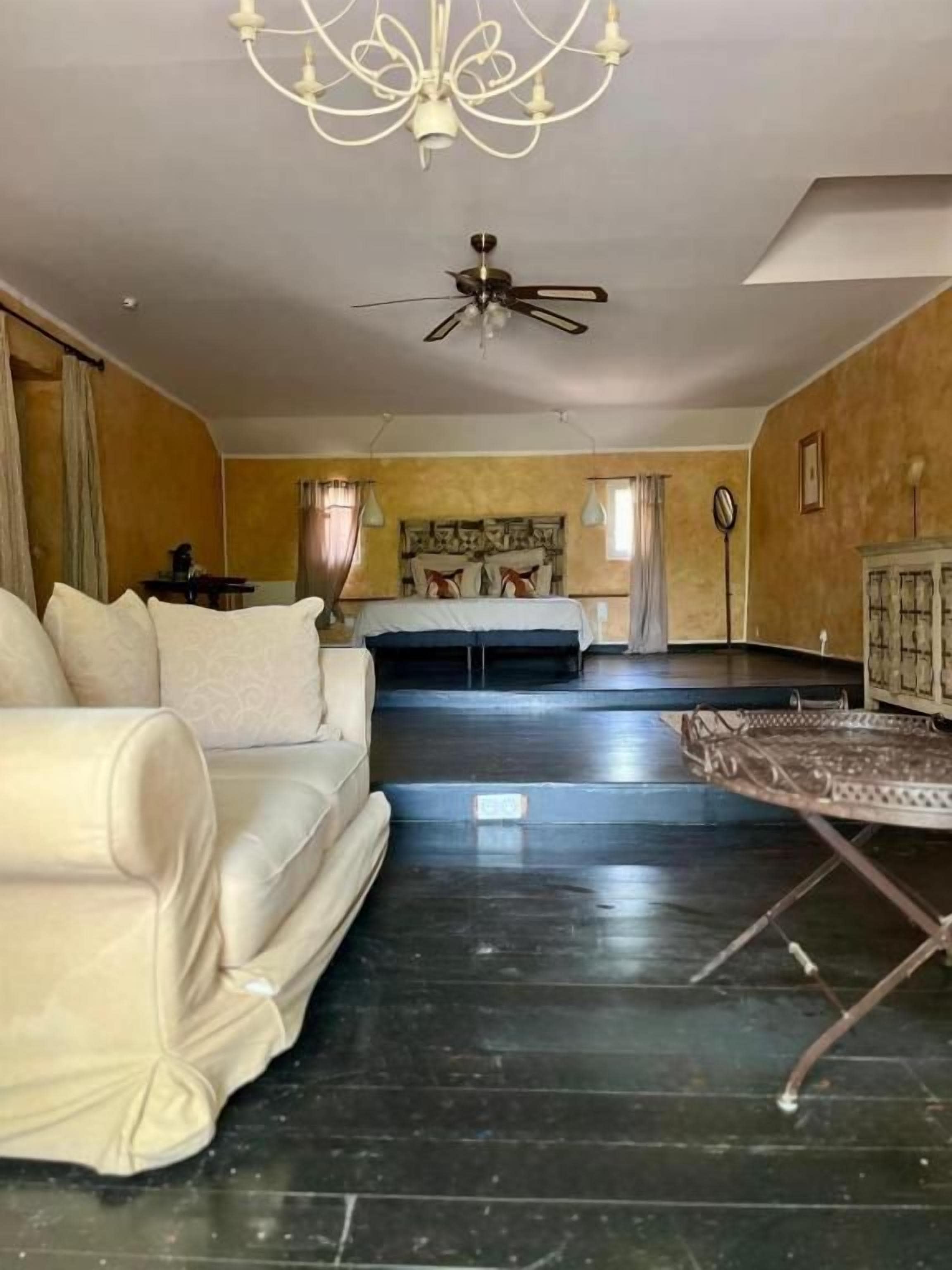 A spacious living area with a sofa, a coffee table, and a ceiling fan.