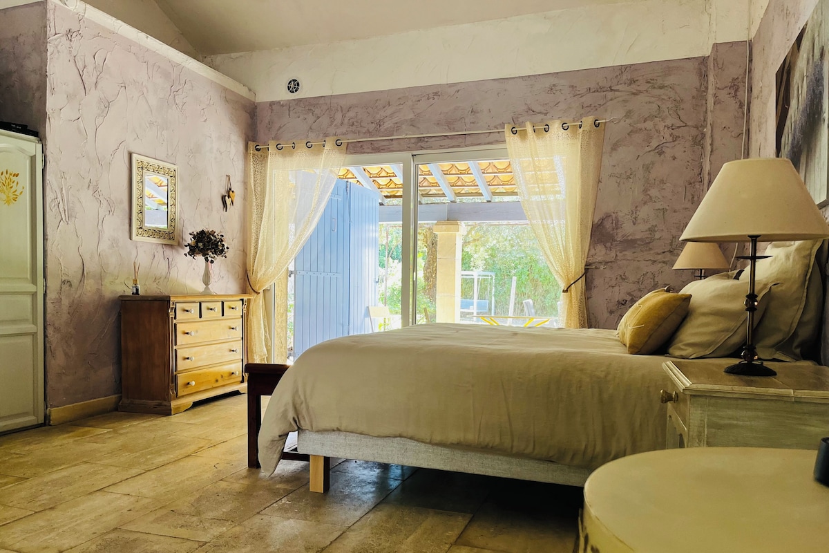 A bedroom with a bed, a nightstand, a dresser, and a window with curtains.