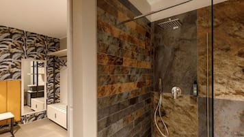 A modern bathroom with a shower, tiled walls, and a mirror.