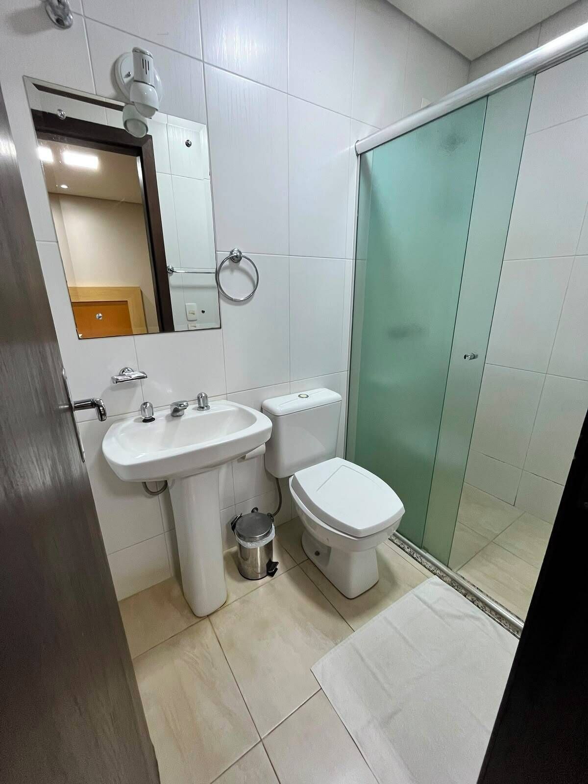 A bathroom with a sink, toilet, and glass shower enclosure.