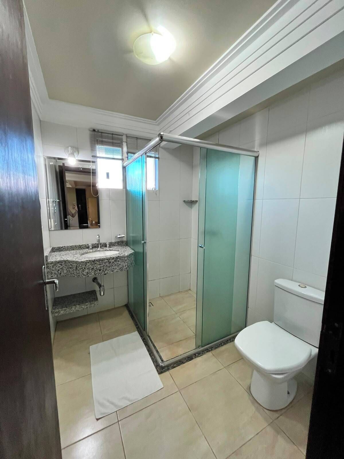 A bathroom with a shower, toilet, and sink.
