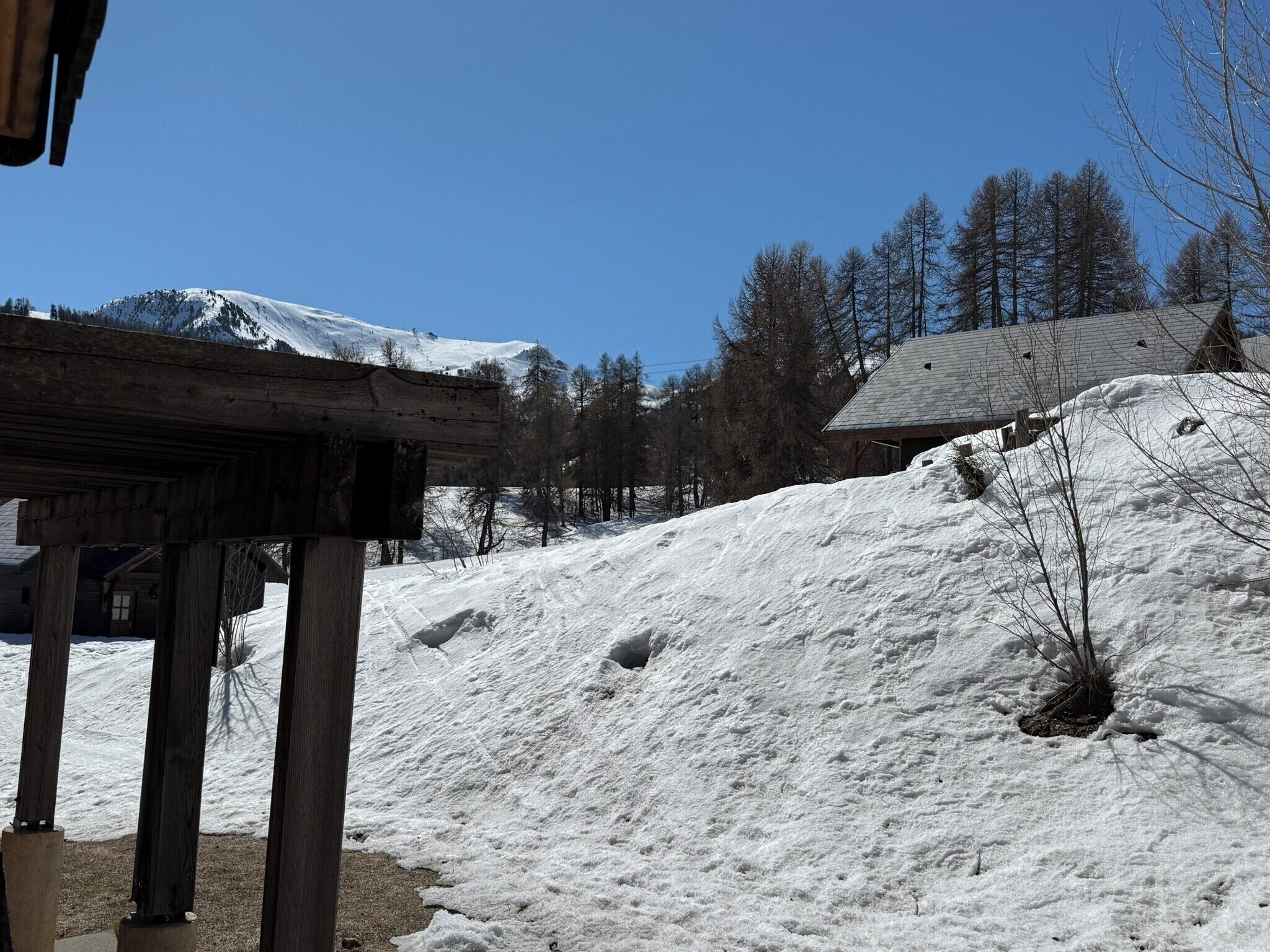A wooden structure with a snow-covered hill in the background.