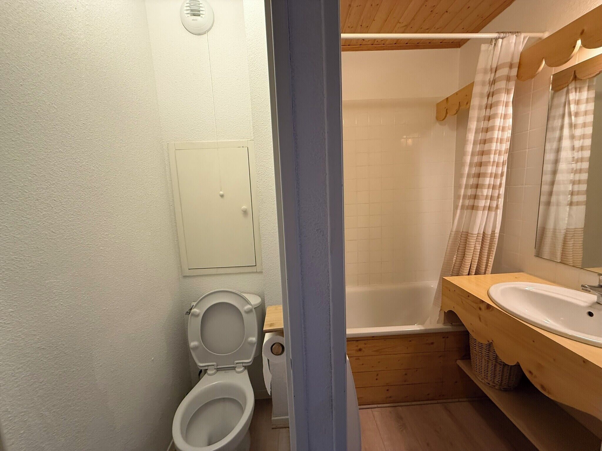 A bathroom with a toilet, a shower, and a sink.