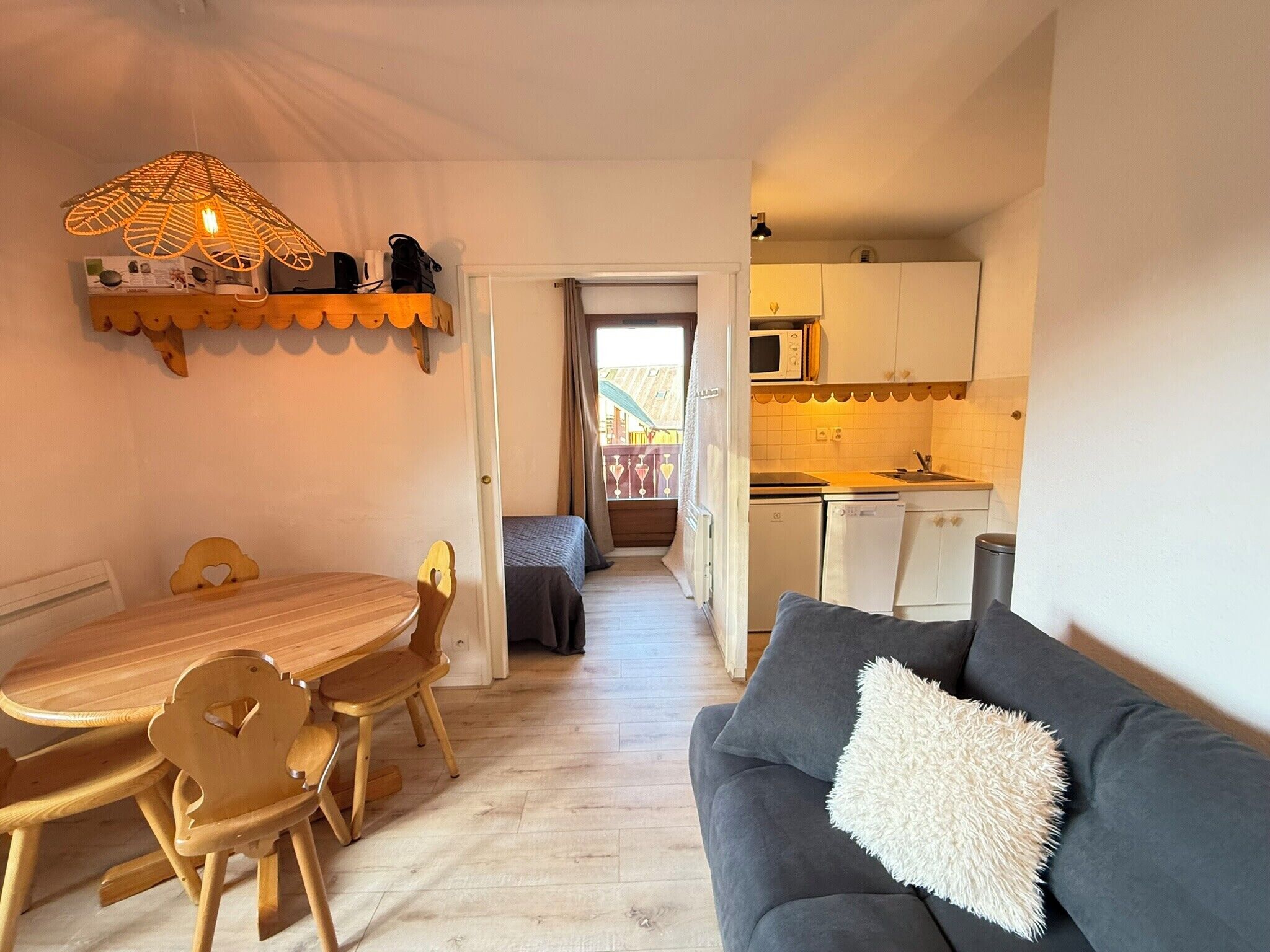 A compact living space with a dining area, kitchenette, and a sofa.