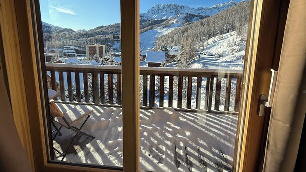 A balcony with a view of snow-covered mountains and a lake. - Appart 6 pers - proche pistes et vue montagne (Vars)